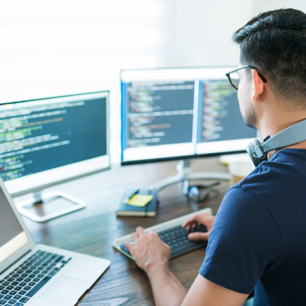 Hispanic Male Programmer Coding At Desk